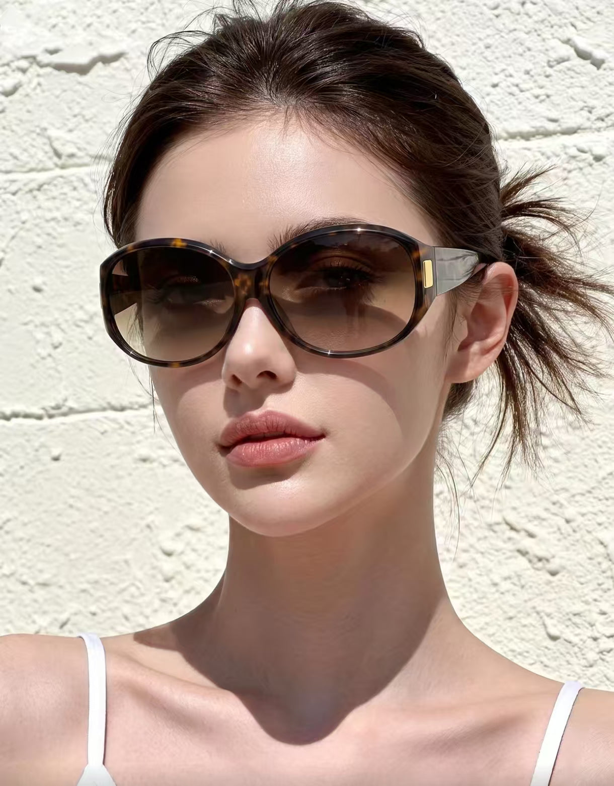 Woman wearing tortoise shell full-rim oversized rounded-square polycarbonate sunglasses, front portrait